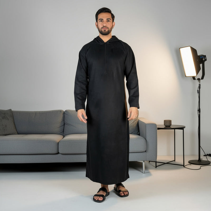 Model wearing a black hooded suede thobe with a zip neckline.
