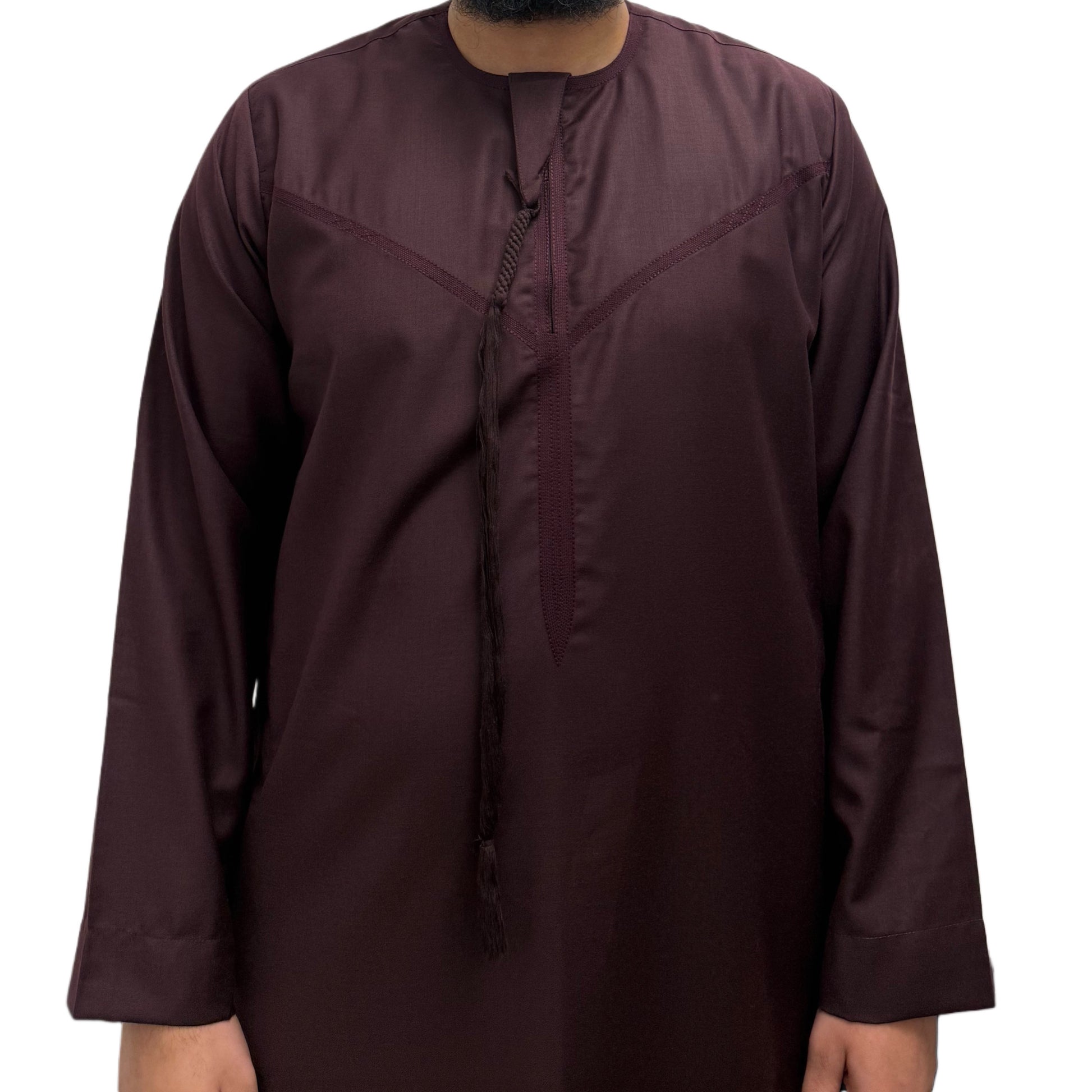 Model standing with hands by his side wearing a Burgundy Omani thobe, minimalist design with clean tailoring