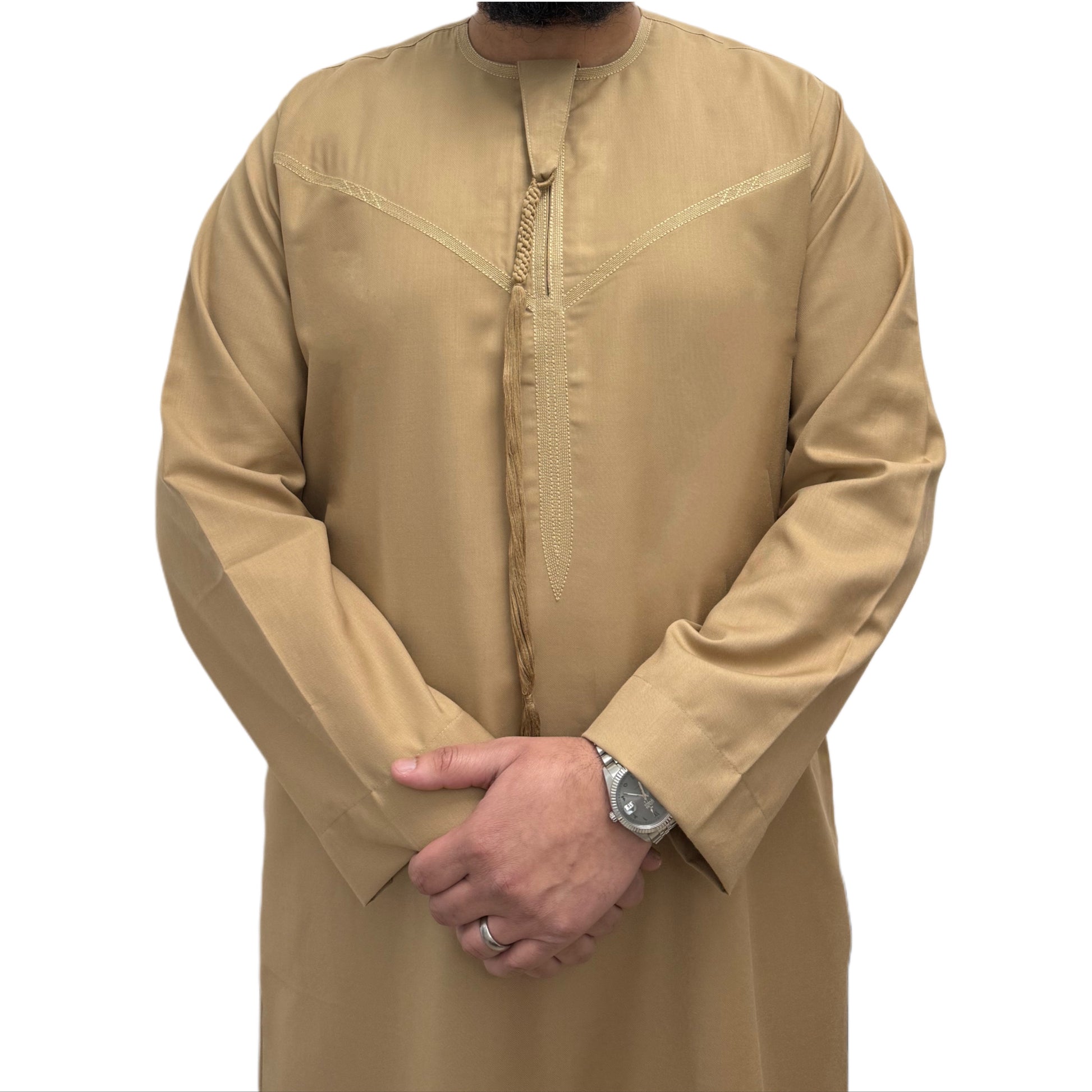 Man wearing a plain Beige Omani thobe with hands crossed, featuring a relaxed fit and traditional tassel detail